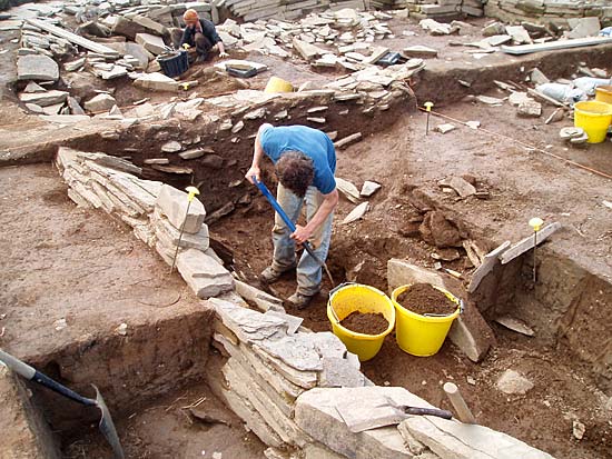 Ian removes the last of the fill from the robber trench along the east wall of Structure 12. Ian removes the last of the fill from the robber trench along the east wall of Structure 12.